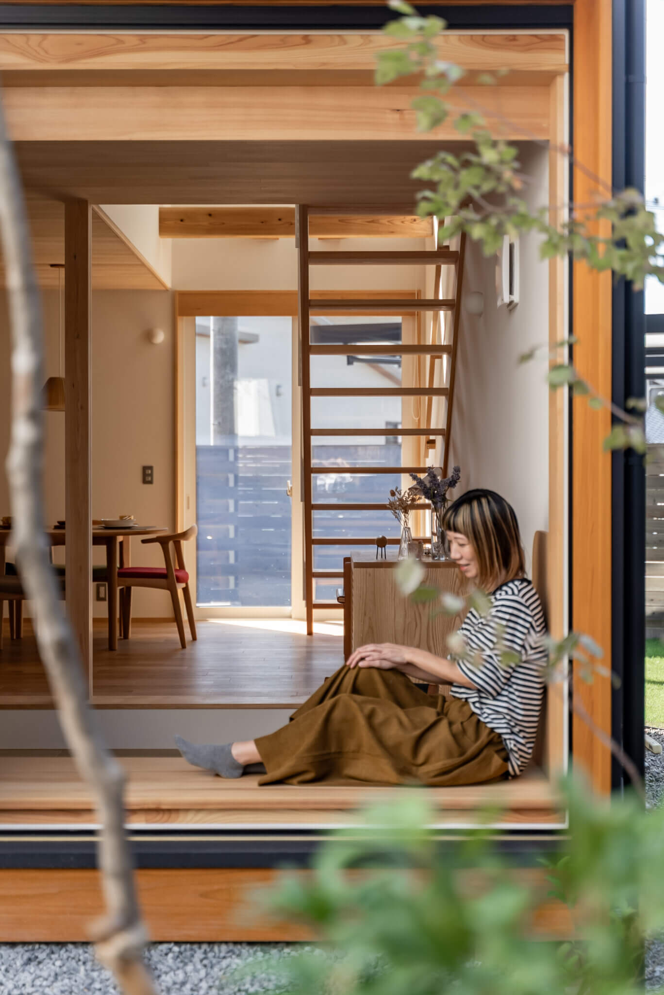 窓辺に座る住まい手と庭